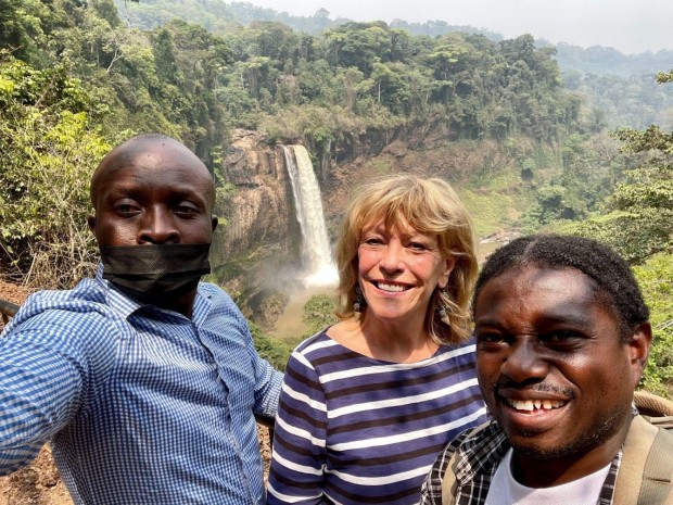 Falling for Cameroon: Franci Neely standing with driver Armand and guide Chemba at the Ekom Nkam Waterfalls in Melong, Cameroon, on Feb. 27, 2022