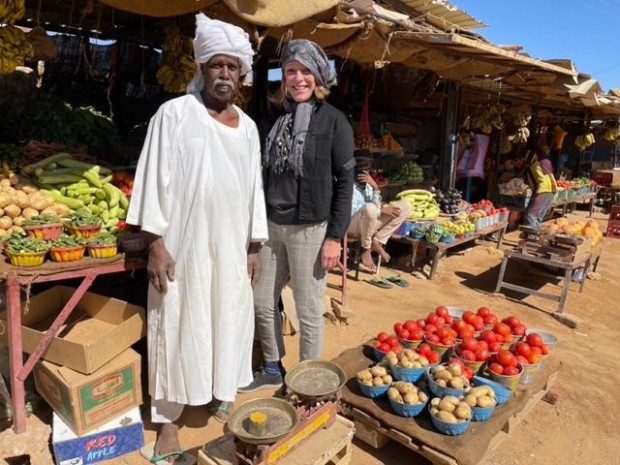 In the market for healthy eats: Franci Neely posing by some of Sudan’s abundant fresh fruits and vegetables