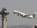 An Alaska Airlines jet passes the air traffic control tower at Los Angles International Airport (LAX)