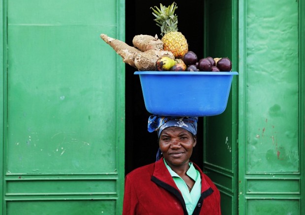 A woman carries fruits and vegetables on her head in Angola.