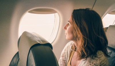 Traveler girl watching through airplane window
