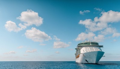A picture of a cruise ship in the ocean, sailing towards a destination with Royal Holiday Vacation Club.