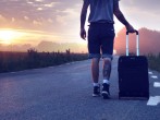 Man With Luggage on Road during Sunset